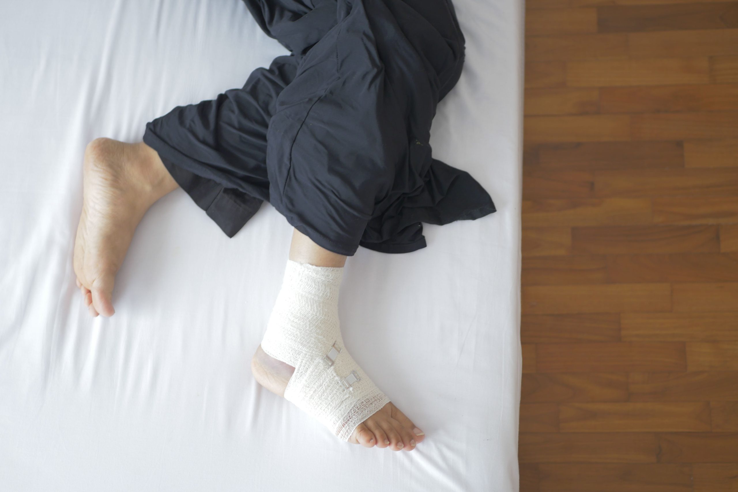 Pied bandagé en convalescence sur un lit.