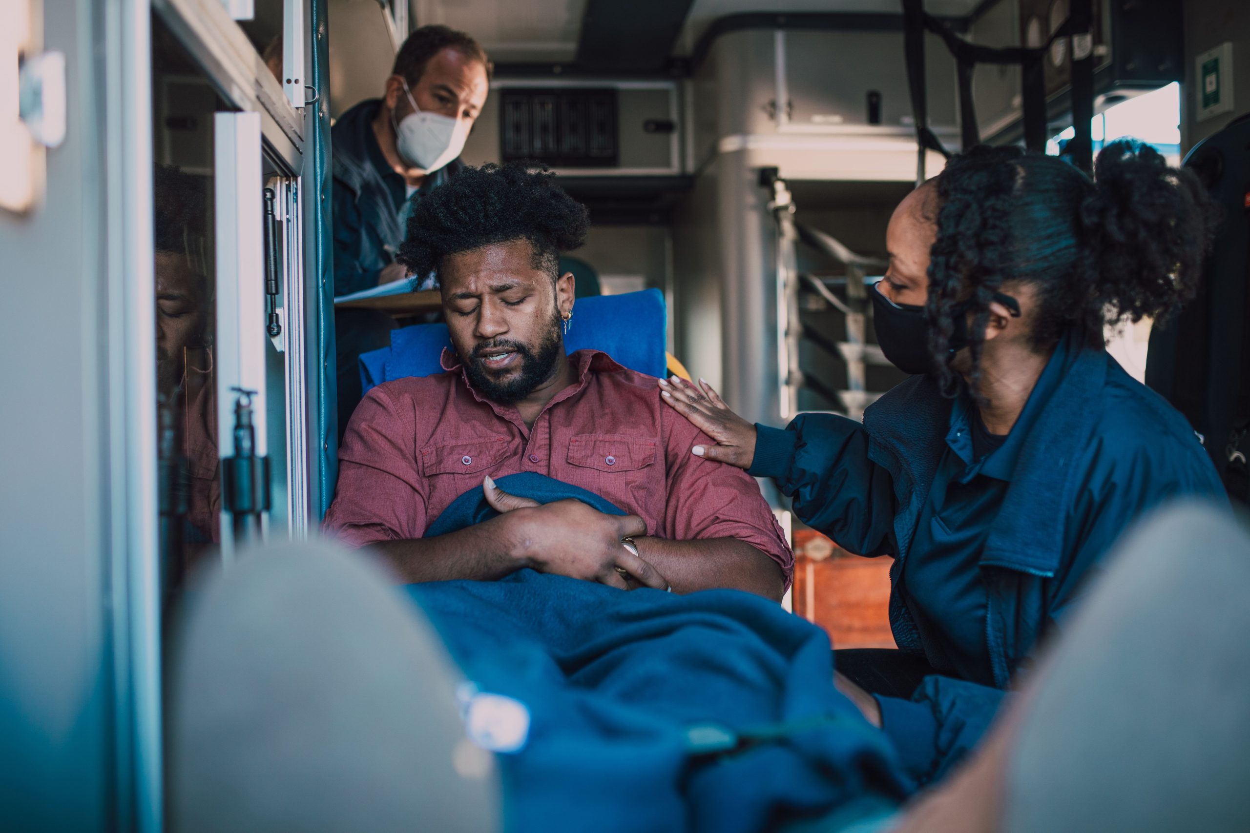 Paramédicaux soignant un patient dans une ambulance.