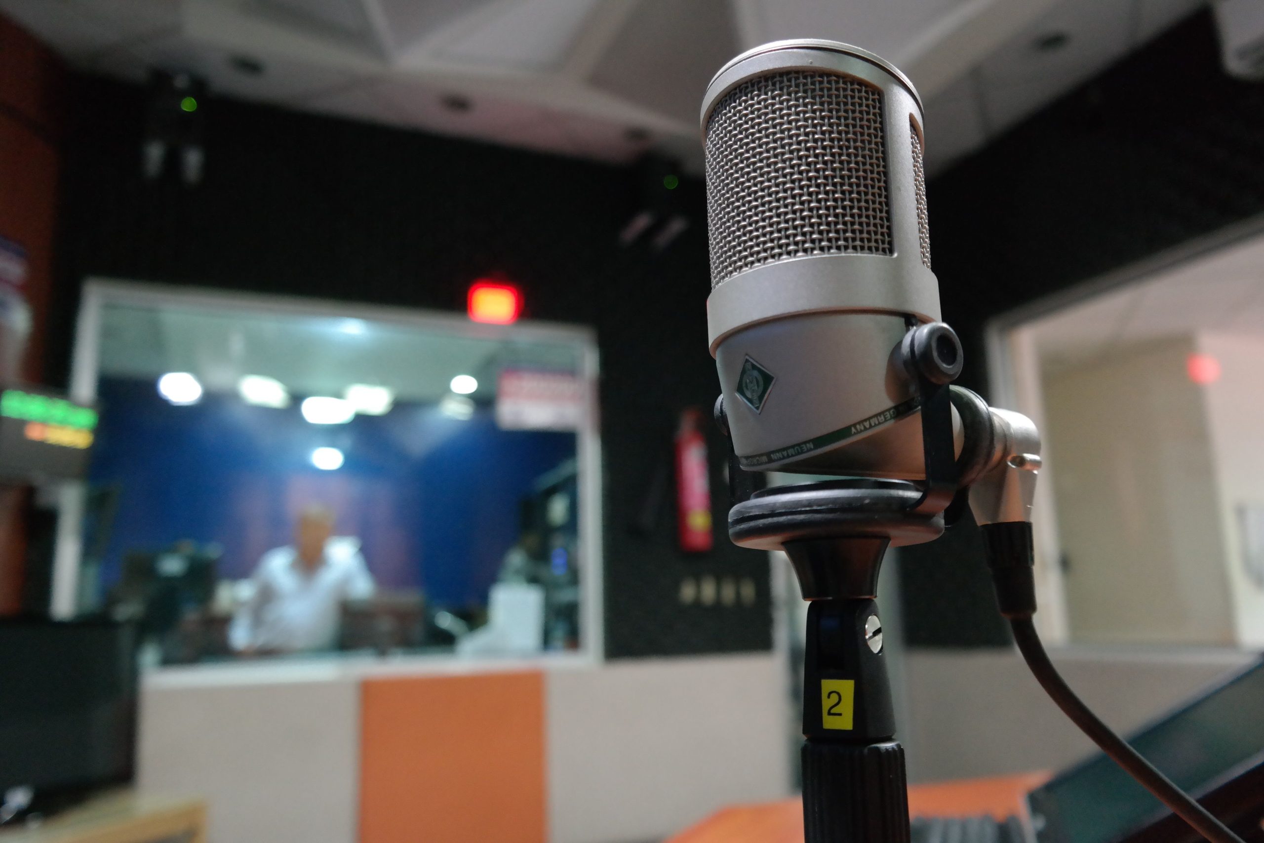 Microphone studio avec ingénieur son en arrière-plan