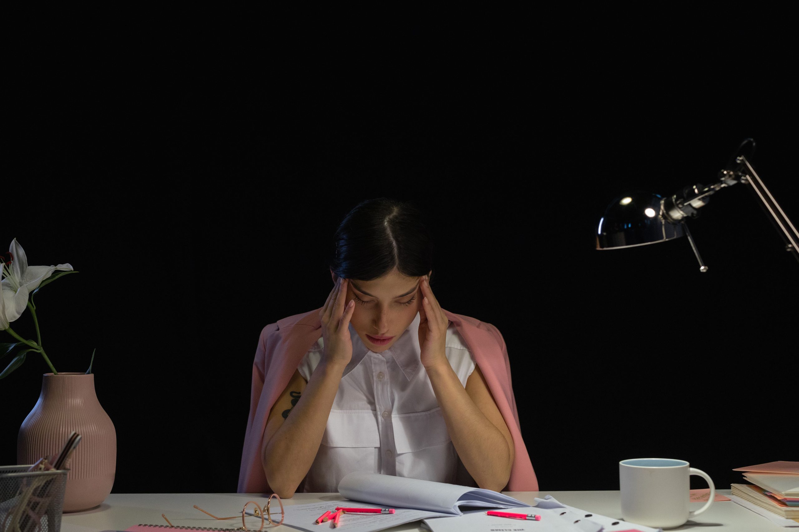 Femme stressée à son bureau les mains sur la tête