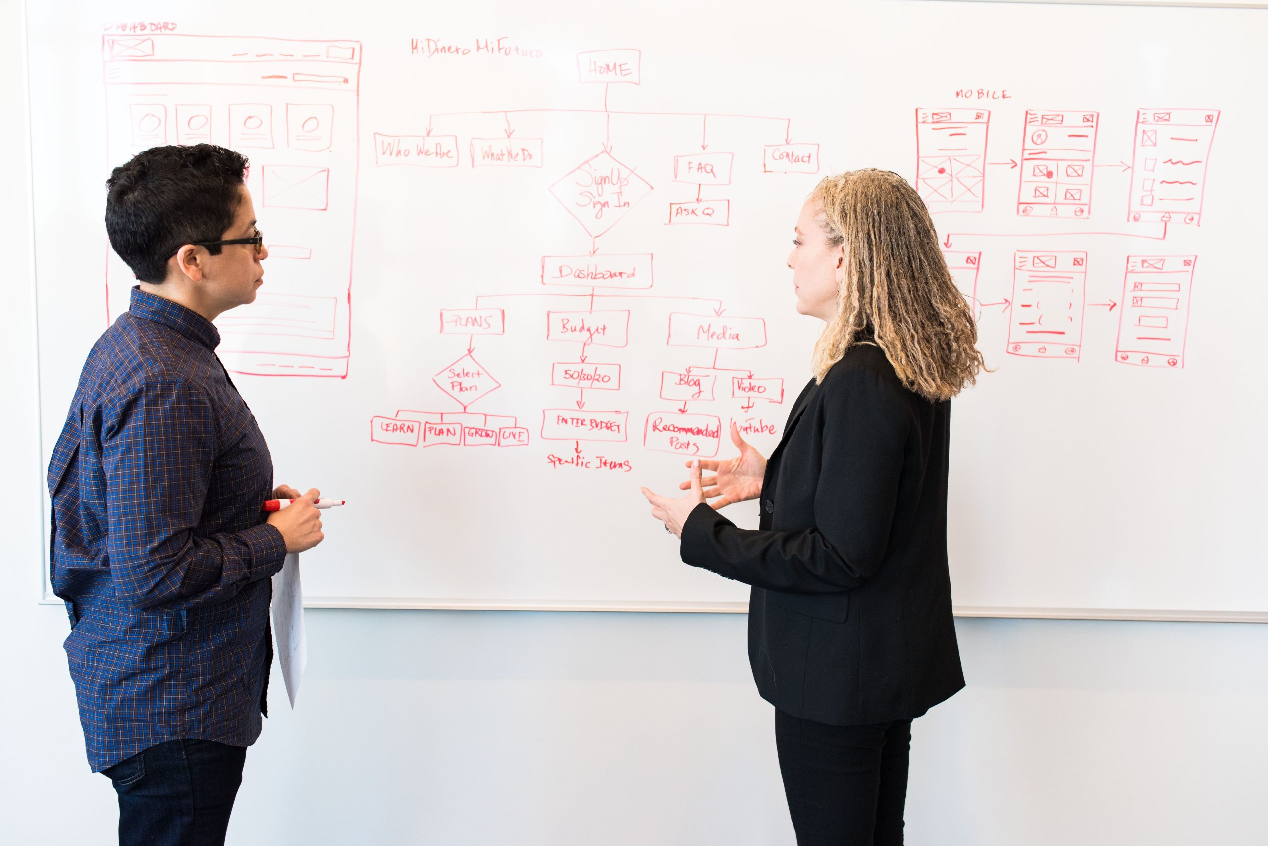 Deux experts brainstorming marketing digital tableau