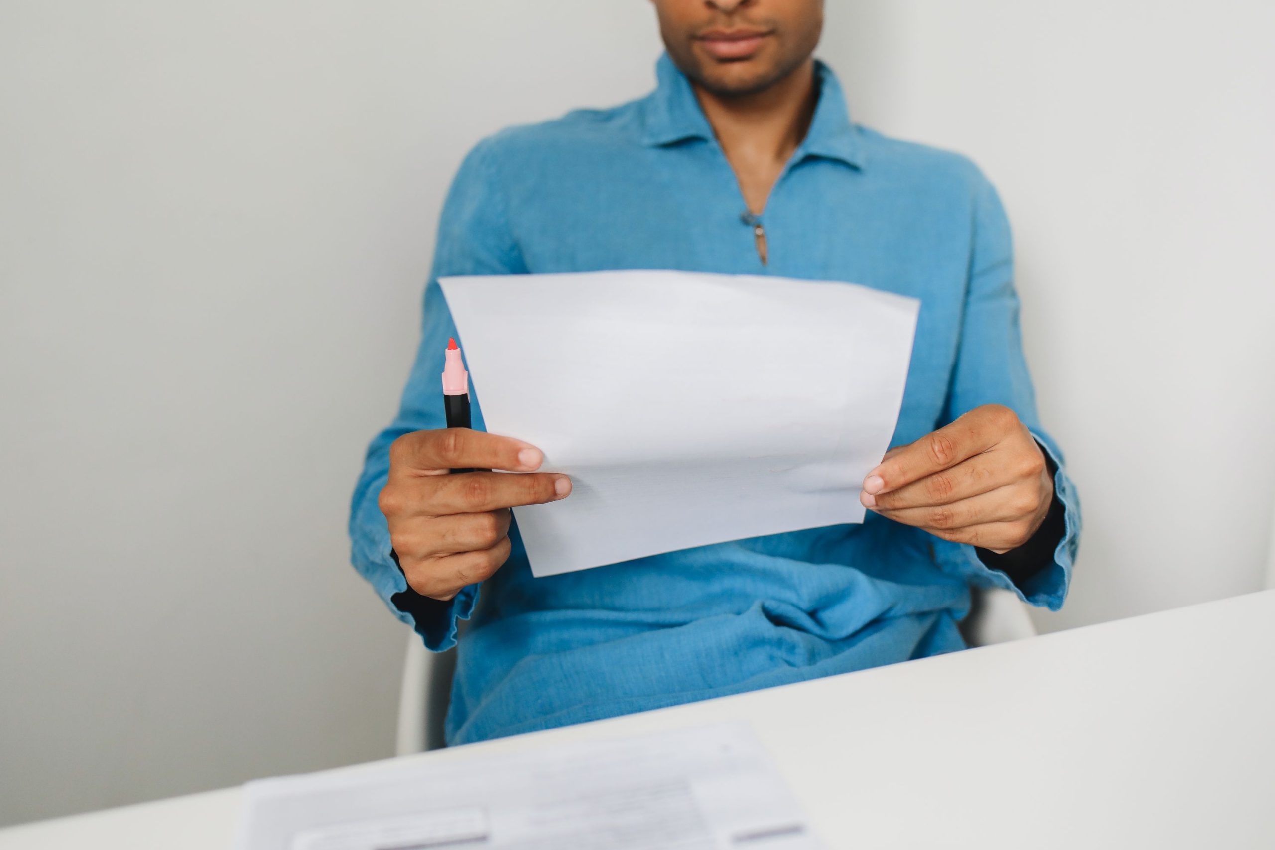 Homme examinant un papier avec un stylo