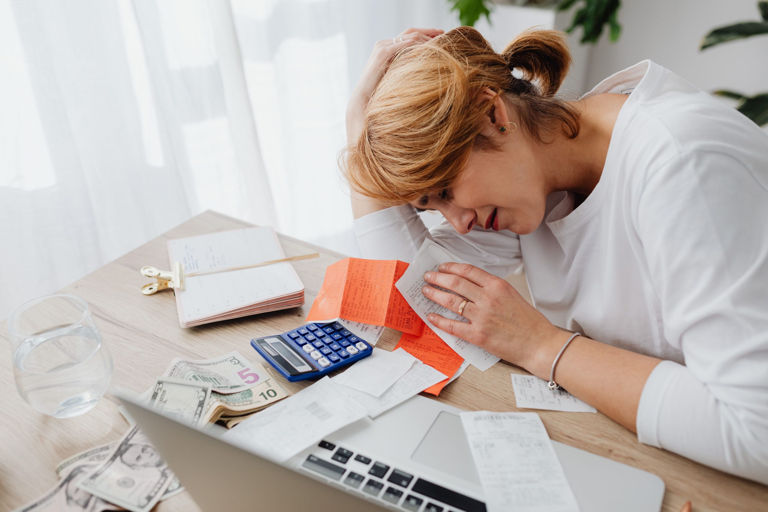 Femme entourée de factures et calculatrice financière