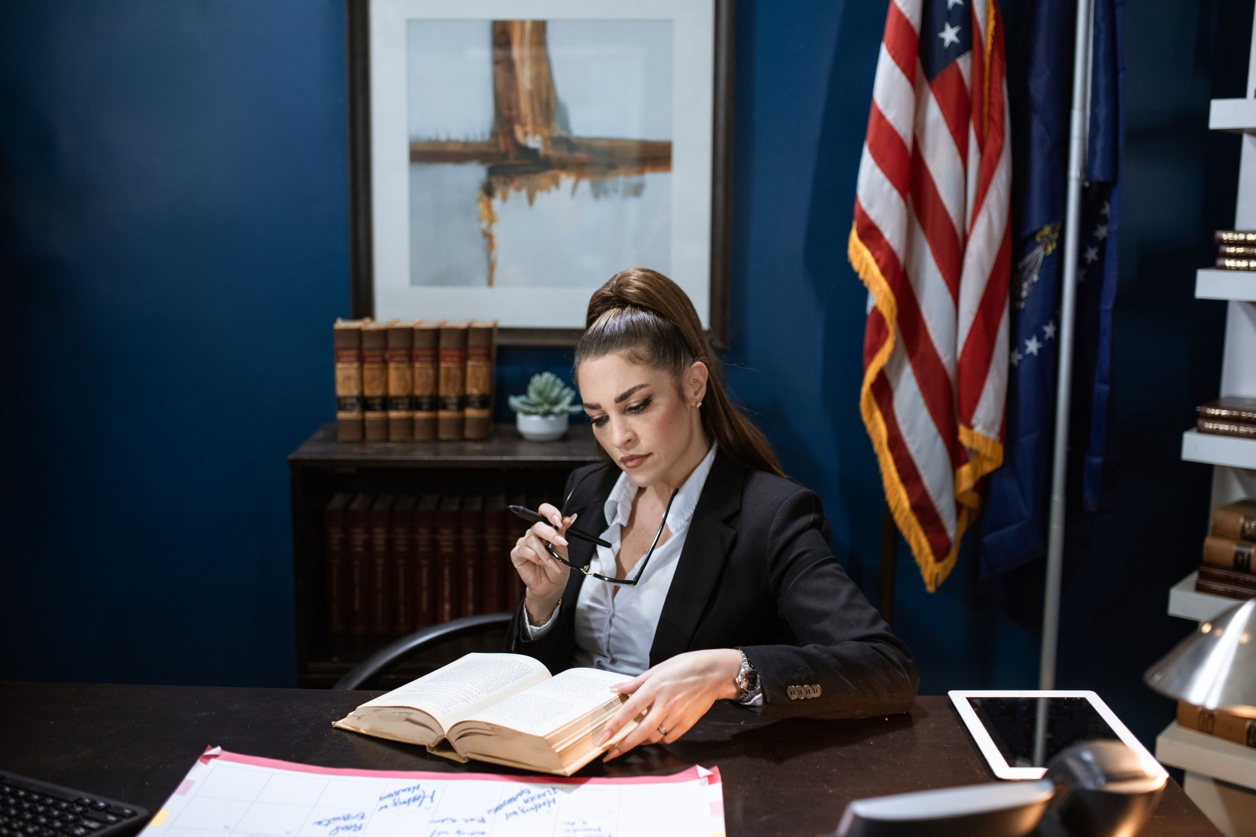 Femme en blazer noir lisant document bureau