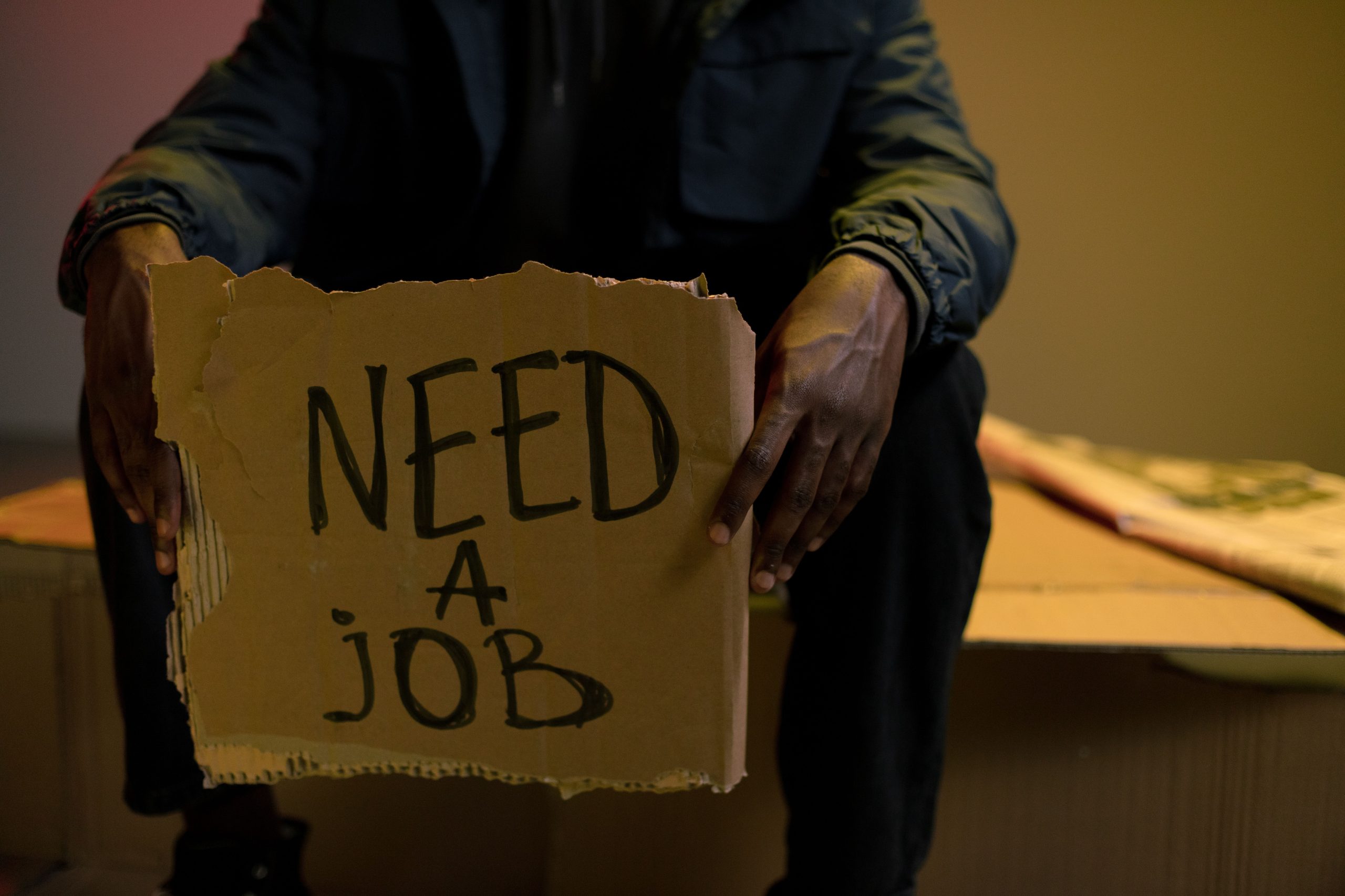 Homme tenant panneau recherche d'emploi