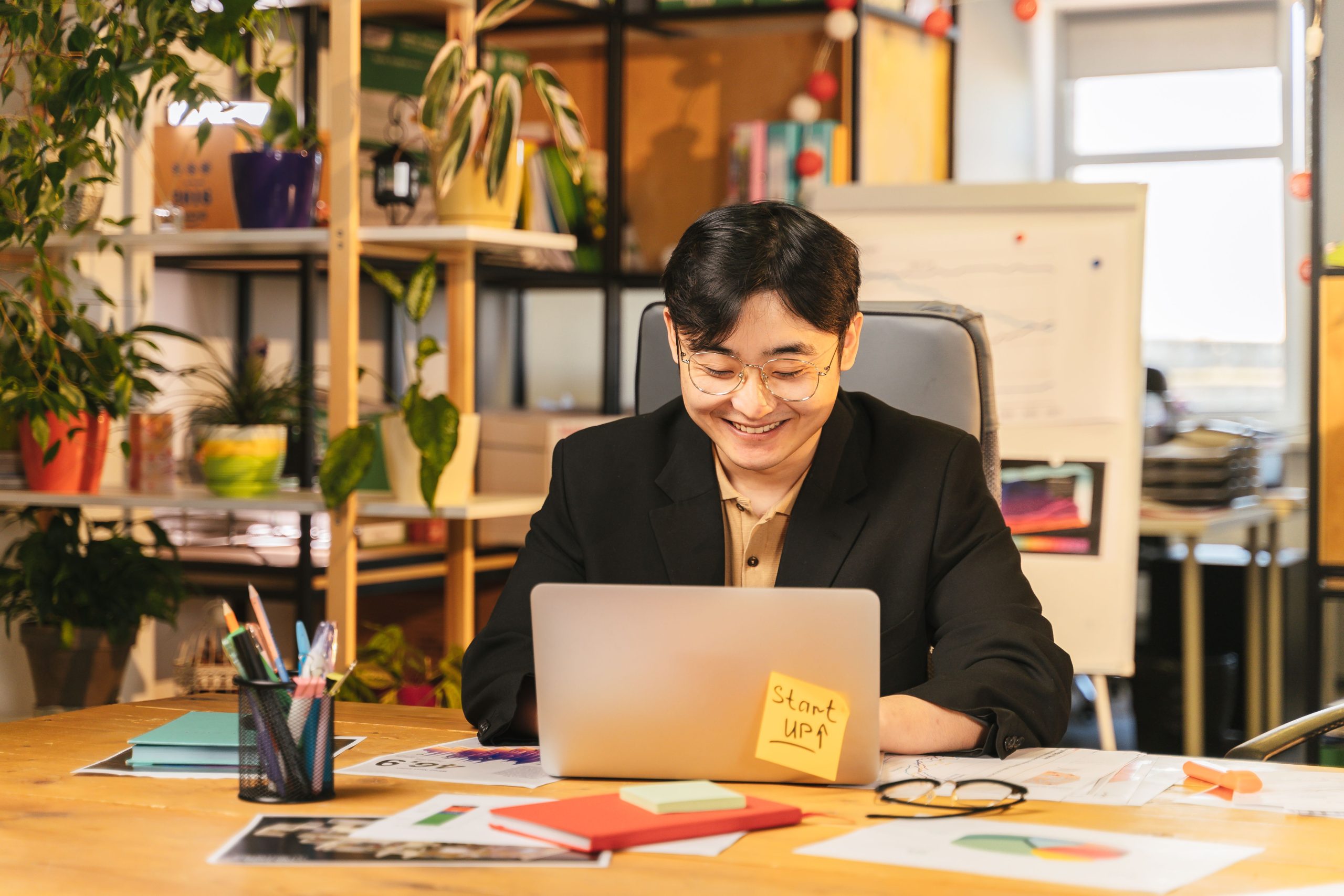 Professionnel souriant au bureau avec plantes vertes