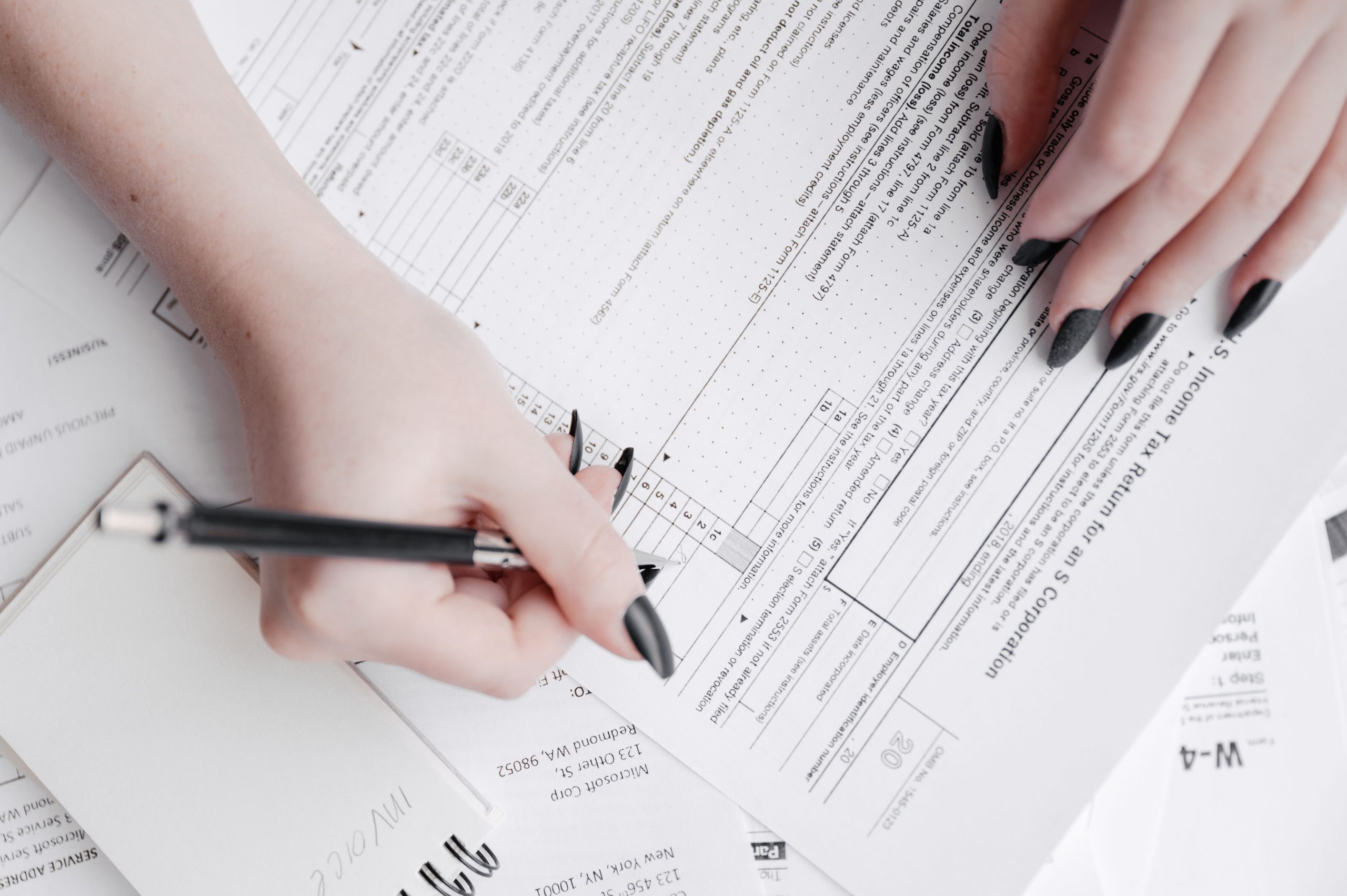 Femme remplissant formulaires impôts avec stylo