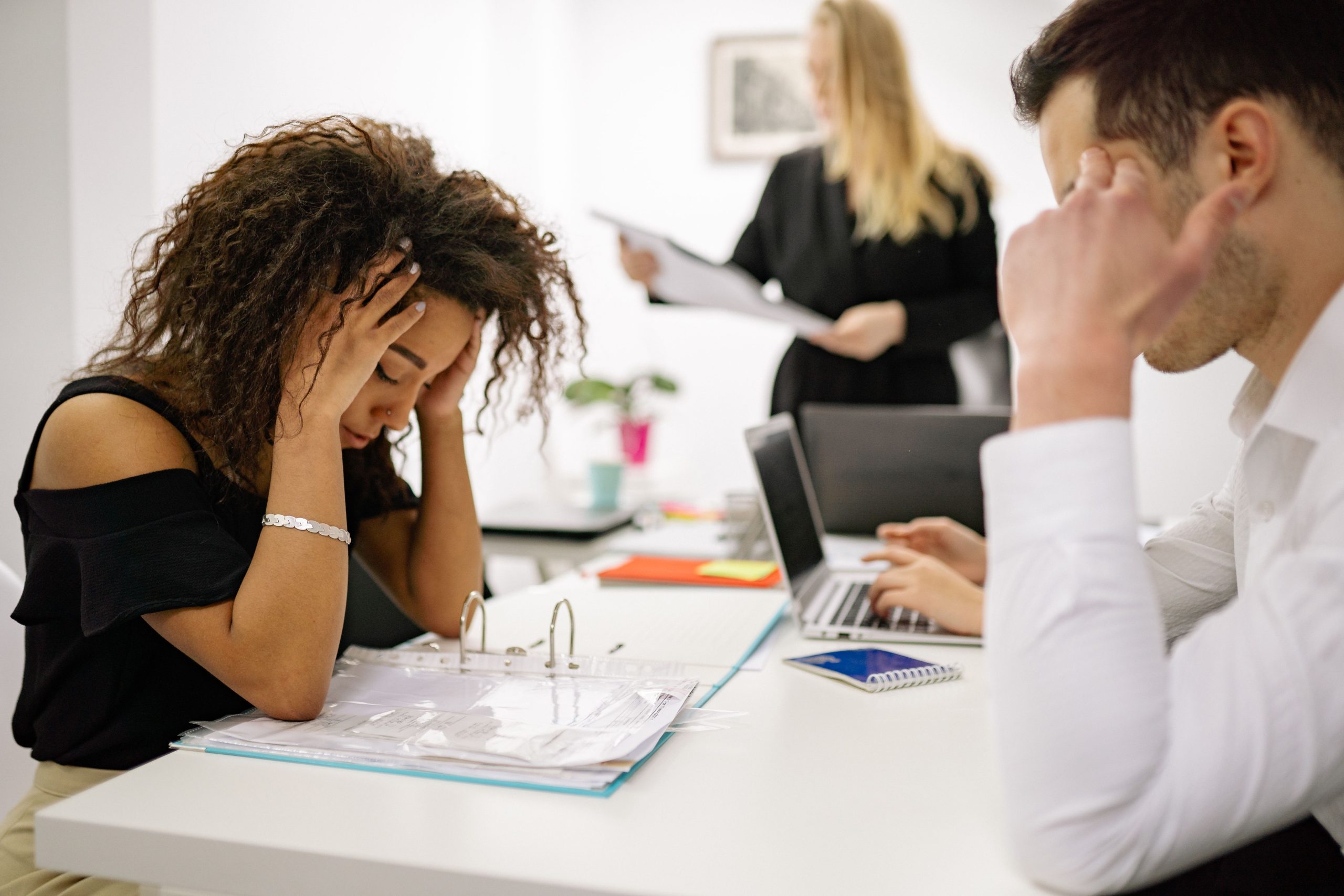Femme stressée au bureau avec collègues à proximité