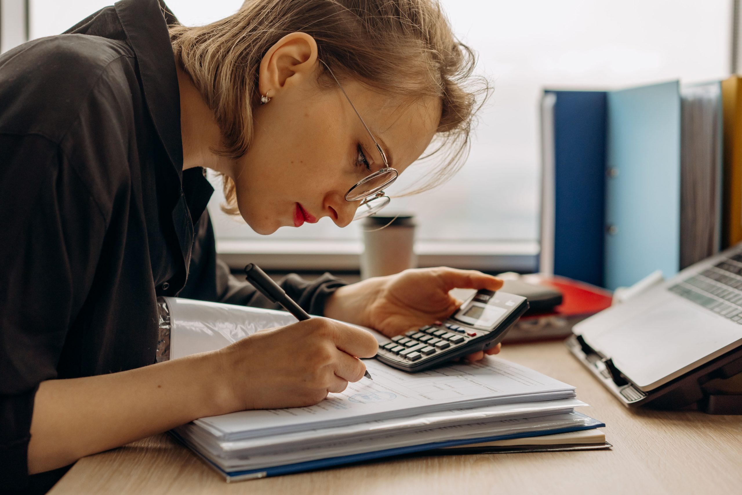 Jeune femme travaillant comptabilité avec calculatrice