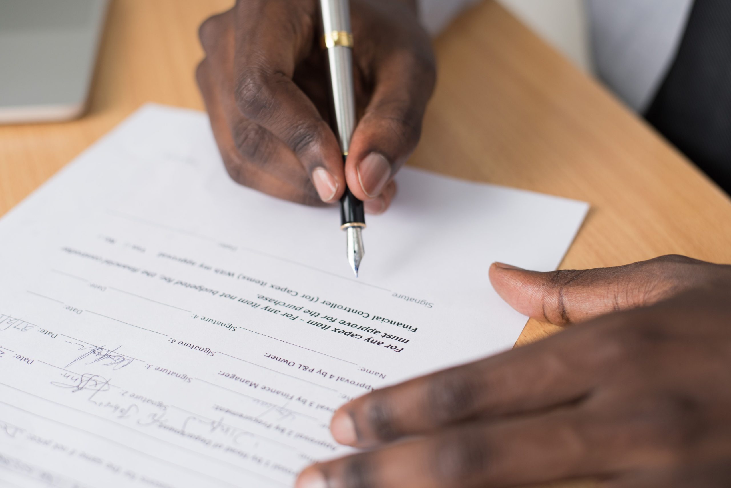 Homme signant document formel en intérieur