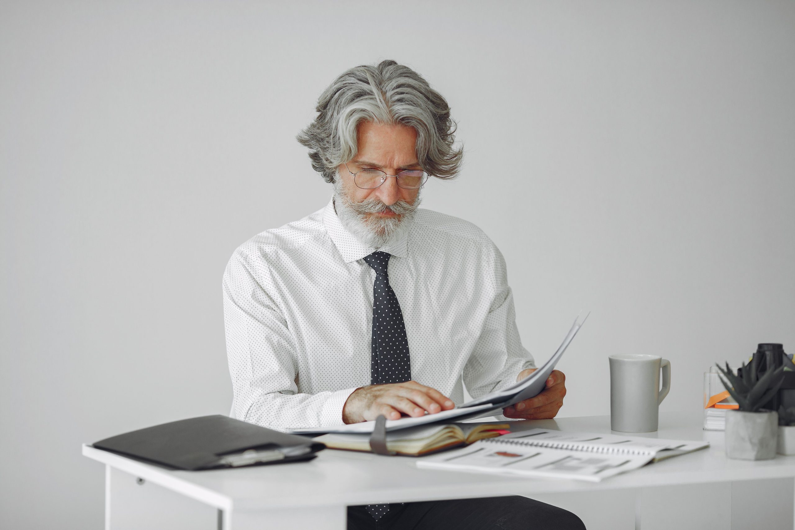 Homme d'affaires âgé consultant des documents à son bureau
