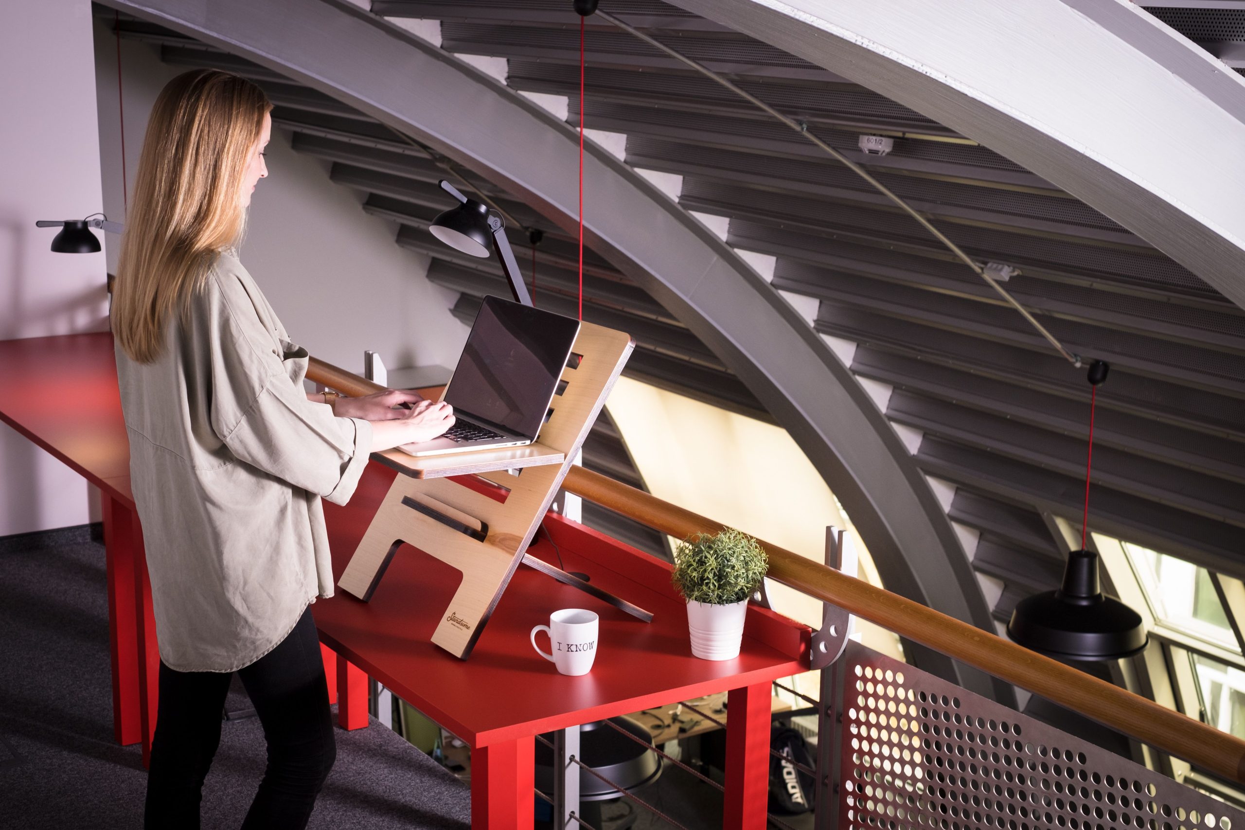 Femme utilisant un ordinateur portable sur bureau assis debout