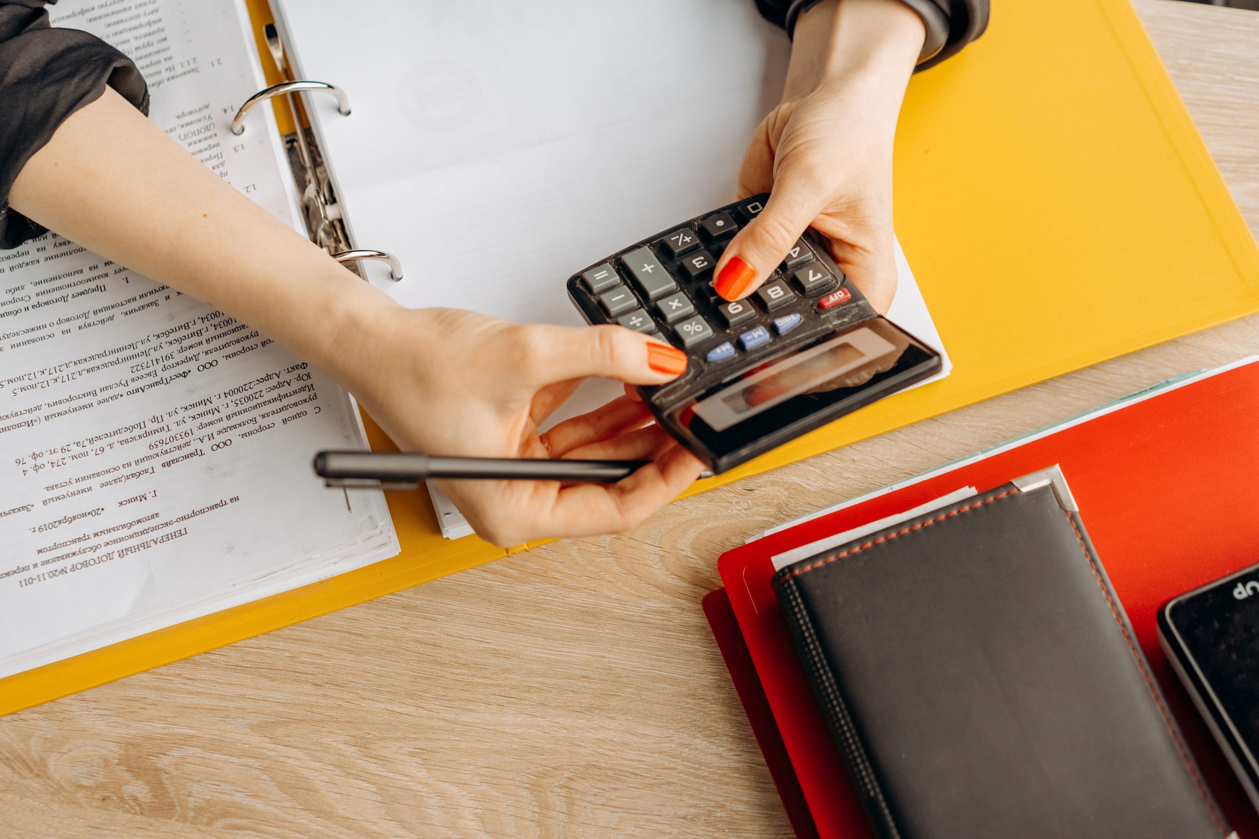 Mains utilisant calculatrice avec documents et dossiers