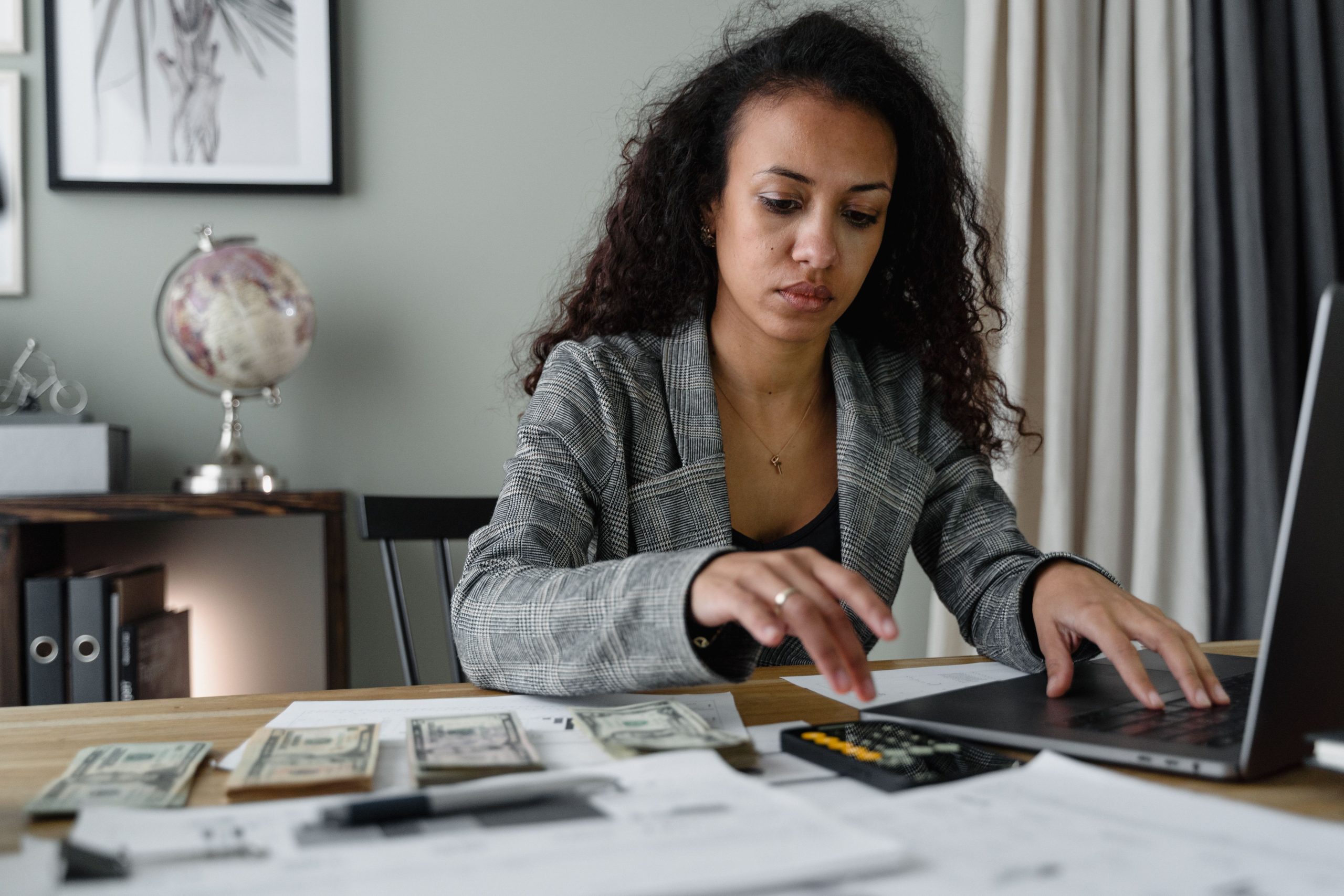Femme analysant documents financiers et comptant argent