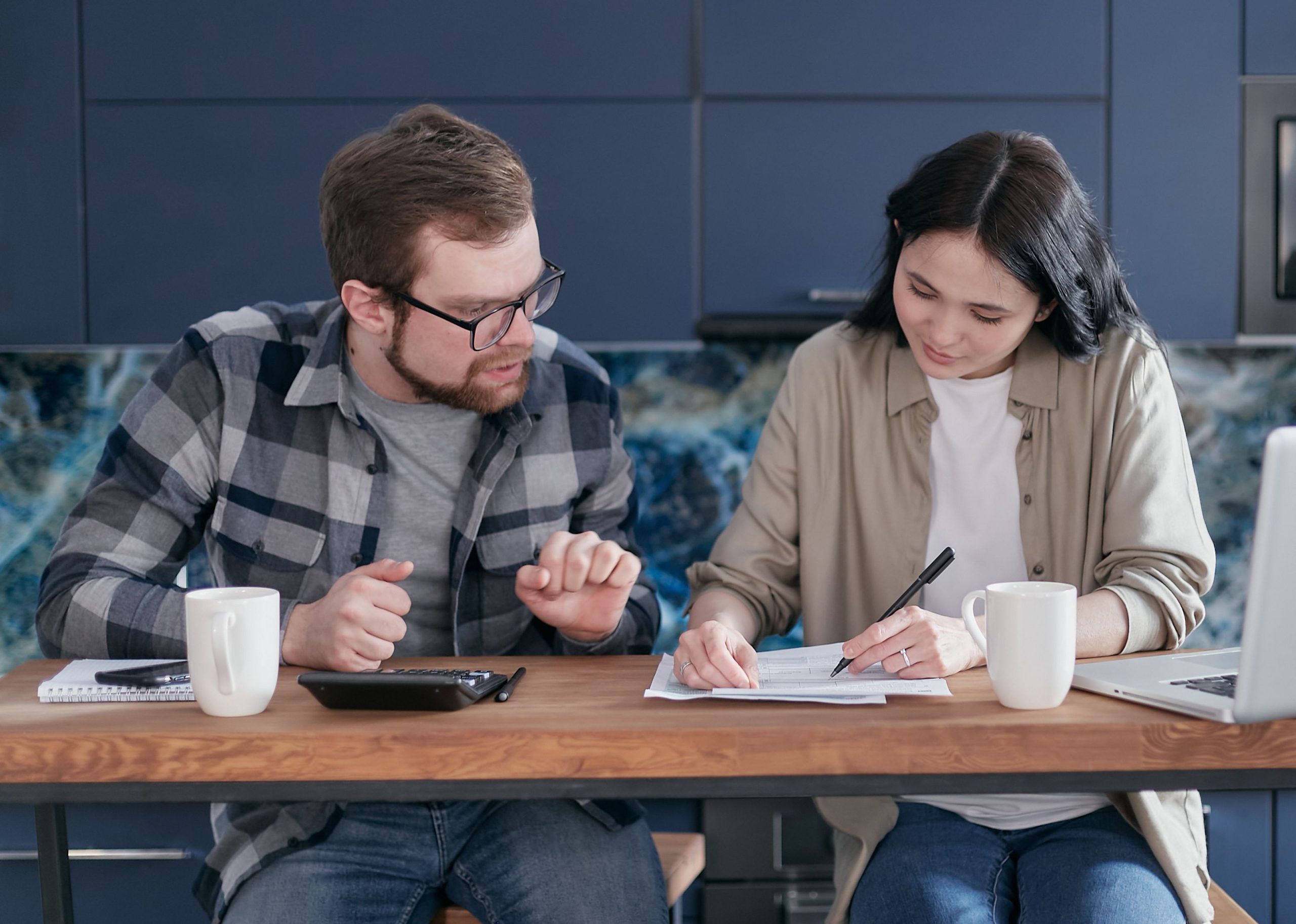 Couple gérant finances avec ordinateur et calculatrice