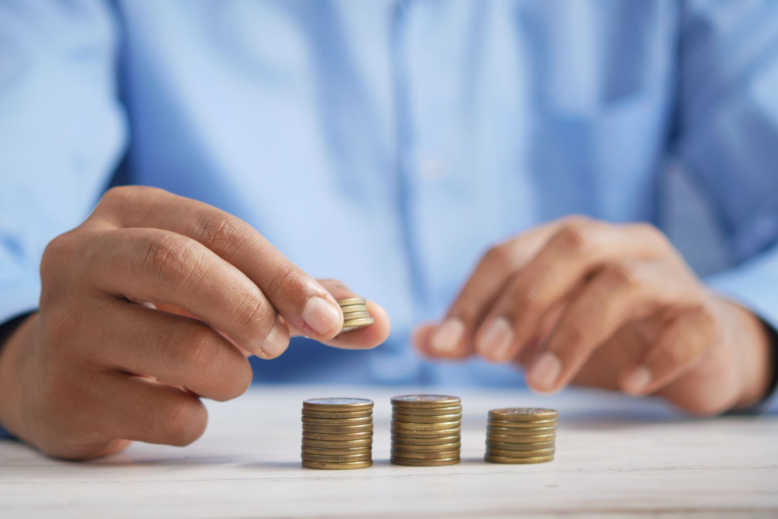 Mains empilant des pièces en or dorées