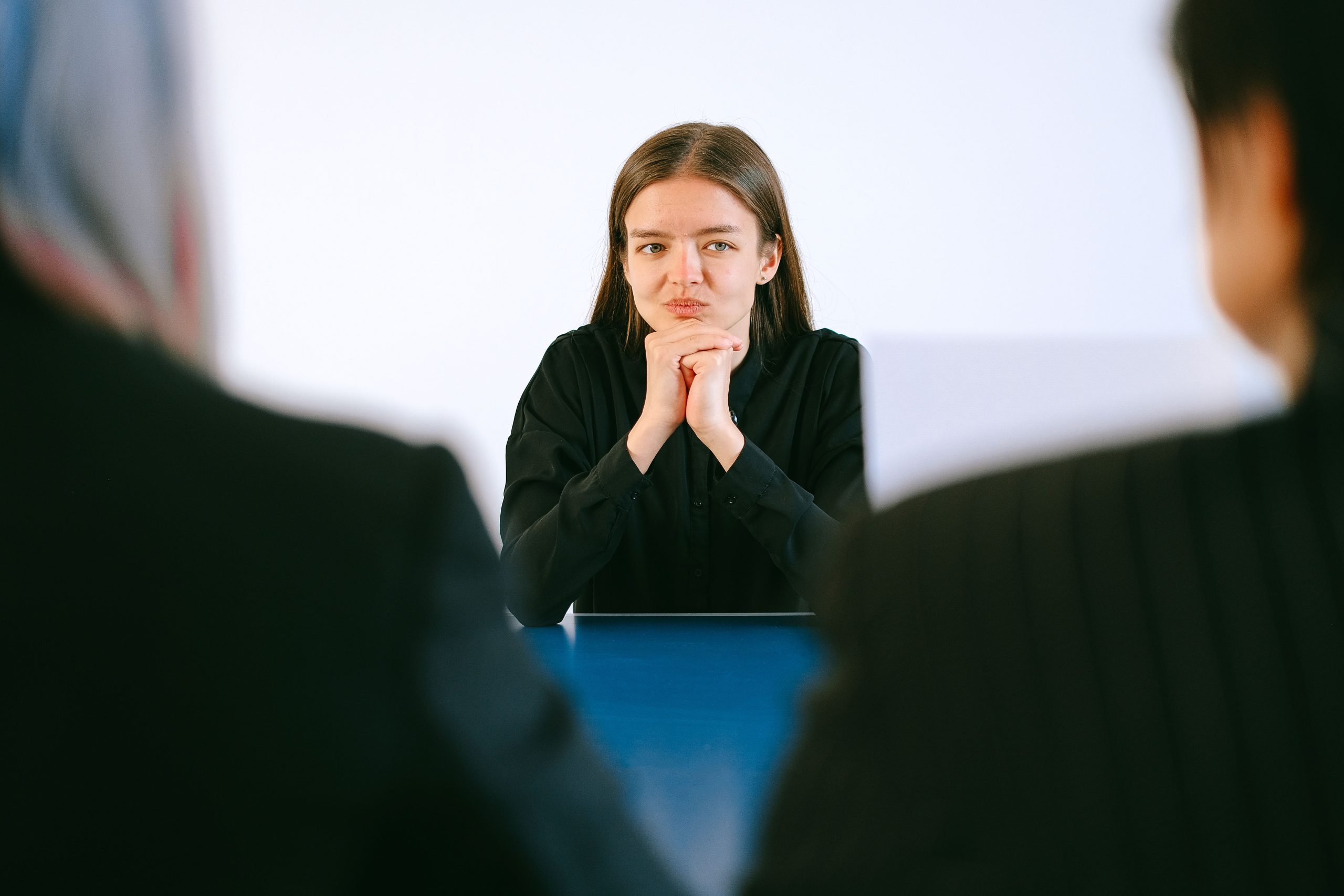 Femme en entretien face à deux recruteurs concentrés