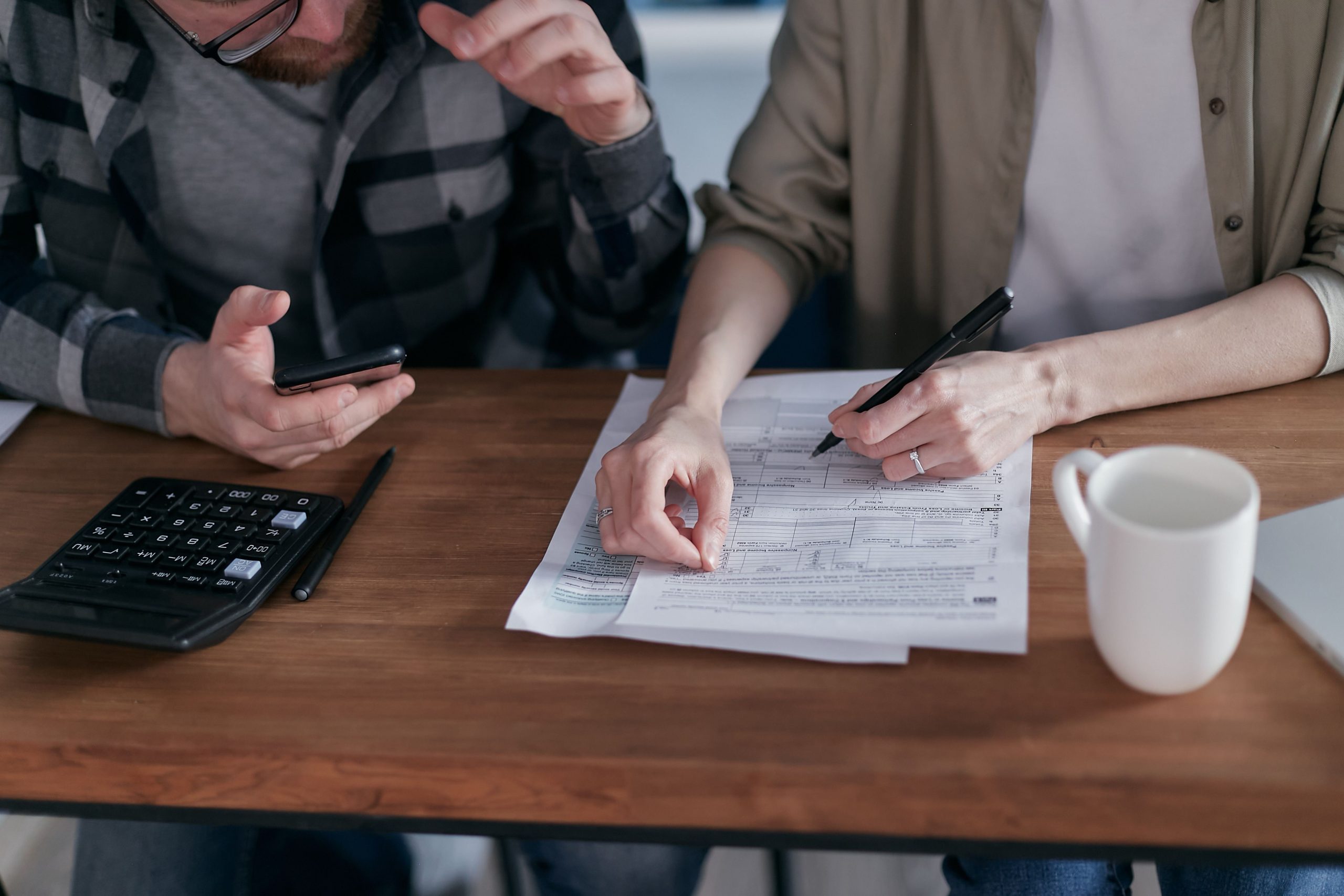 Couple collaborant gestion finances papiers calculatrice