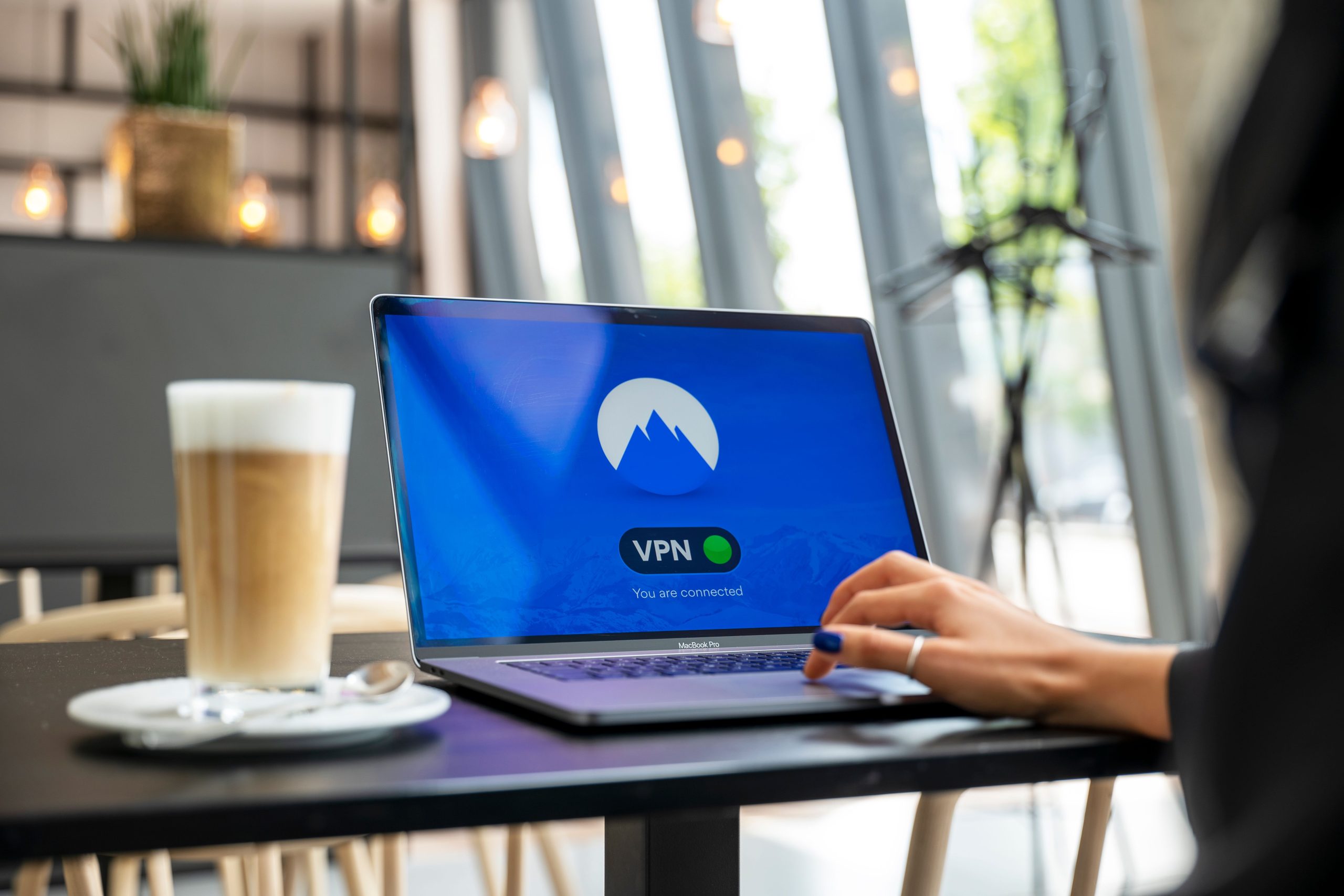Personne travaillant sur ordinateur avec connexion VPN au café